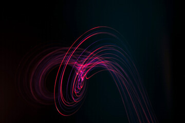 Light trails with swirling pattern on black background