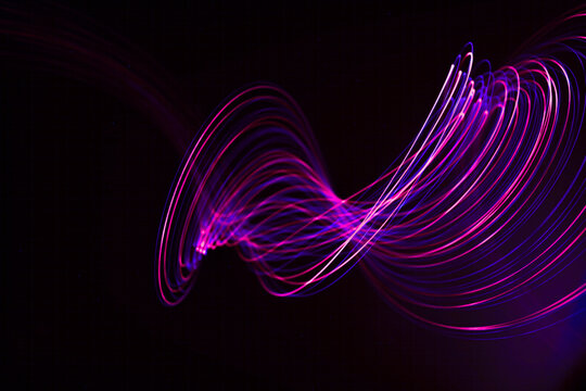 Swirling light trails against dark background