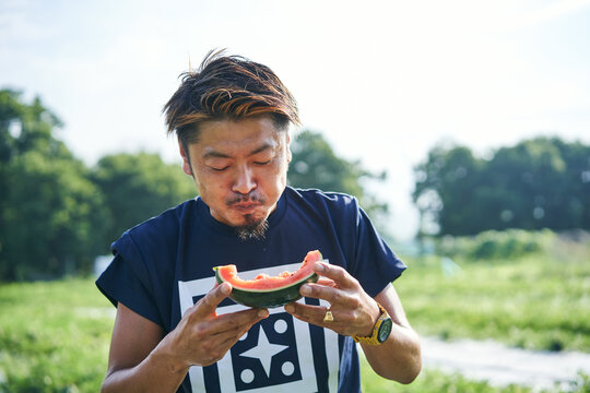 収穫した小玉スイカの味見をする日本の農家さん