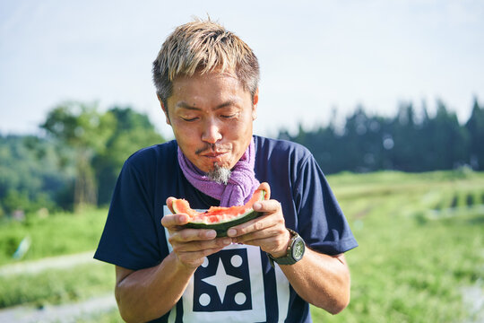 収穫した小玉スイカの味見をする日本の農家さん