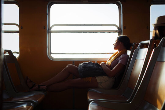 Woman with backpack relaxing in train