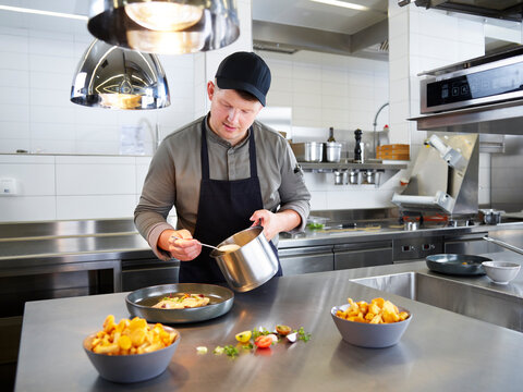 Chef decorating meal in kitchen at restaurant