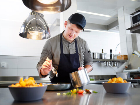Chef garnishing prepared food on table at restaurant