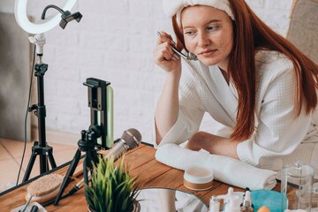 Caucasian female teenager creating beauty tutorial at home with makeup.