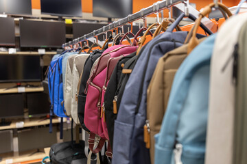 A rack of backpacks and a TV are on display