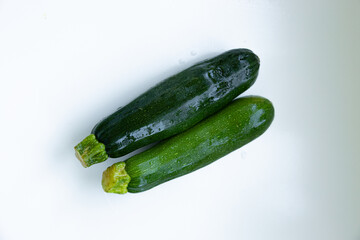 two fresh, green zucchinis placed side by side