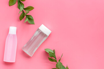 facial tonic and lotion for face care and plant on pink background top view mock up