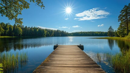 Fototapeta premium Traditional Finnish and Scandinavian view. Beautiful lake on a summer day and an old rustic wooden dock or pier in Finland. Sun shining on forest and woods in blue sky