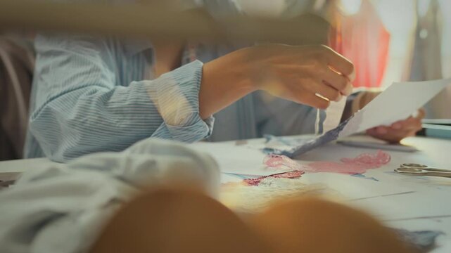 Fashionable girl in work uniform considers different ideas in studio sorting through different types of fabrics lace. Model woman brainstorms search for solution adheres to current fashion standards
