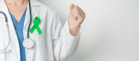 Doctor with green Ribbon for world Lymphoma Awareness September month, world Mental Health Day, Liver, Gallbladders, bile duct, cervical, kidney Cancer. Healthcare and world cancer day concept