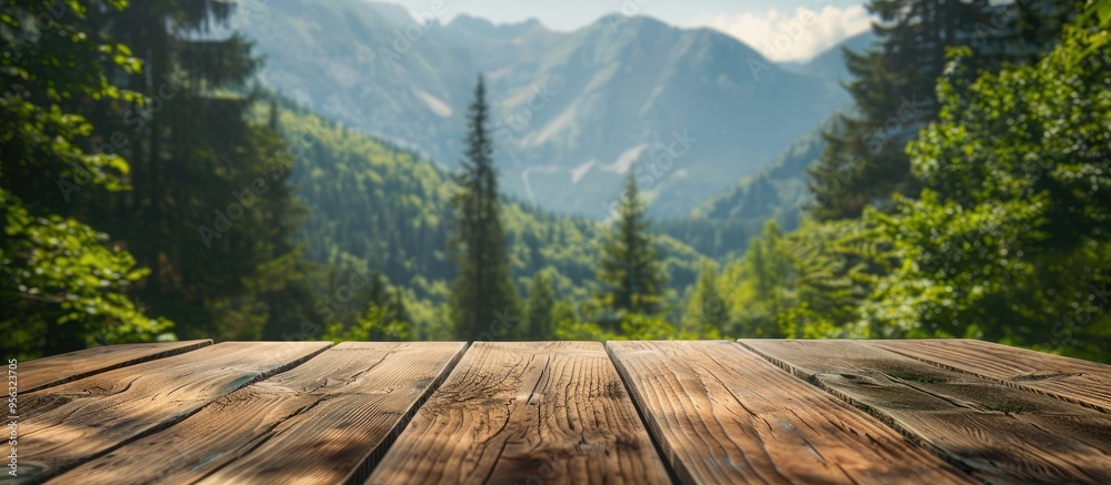 Poster wooden table with a blurred backdrop of mountains and lush greenery providing a copy space image for