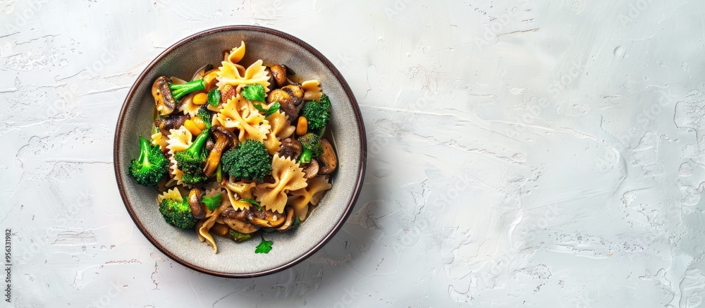 Poster top down view of a dish featuring farfalle pasta roasted broccoli and sauteed mushrooms in a bowl on