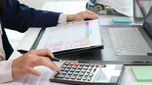 Expert woman asian female people review data number costing managerial account prepare monthly actual cost variance report at tax audit office. ESG sheet budget control ERP process service project.