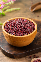 Red beans in a wooden bowl, on a wooden table indoors, close up