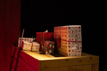 A festive holiday composition featuring beautifully wrapped red gift boxes stacked beneath a...
