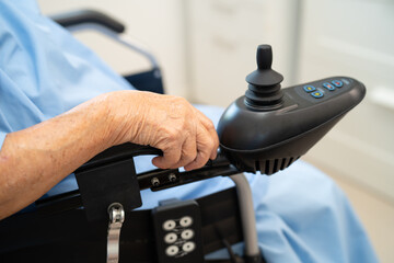 Asian senior woman patient on electric wheelchair with remote control at hospital, healthy strong medical.