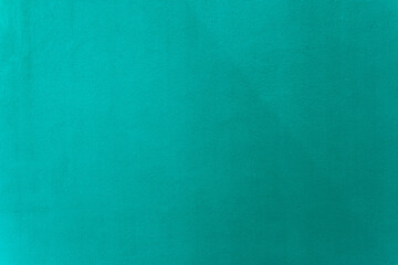 green or turquoise paint on cement wall texture as background.