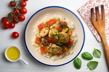 Wok-fried calmares with vegetables over white rice. Food on top view table.