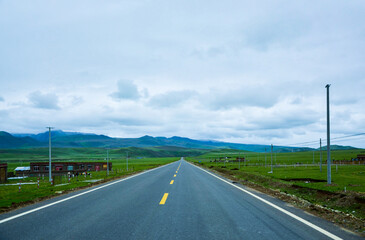 Fototapeta premium Highway view through green grasslands