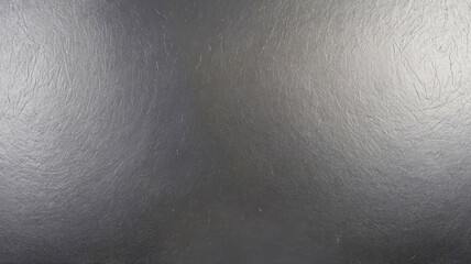 A dark polished surface showcasing a smooth, shiny texture perfect for modern and minimalistic design backgrounds.