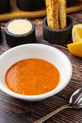 Ezogelin soup in white porcelain plate, on wooden table