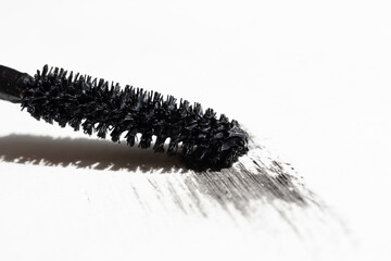 Black mascara with mascara brush on white background