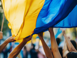 Diverse hands holding a large Ukrainian flag during a public demonstration - Powered by Adobe