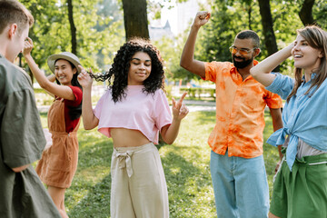 Group of young people dancing together in the park, dancing, having fun
