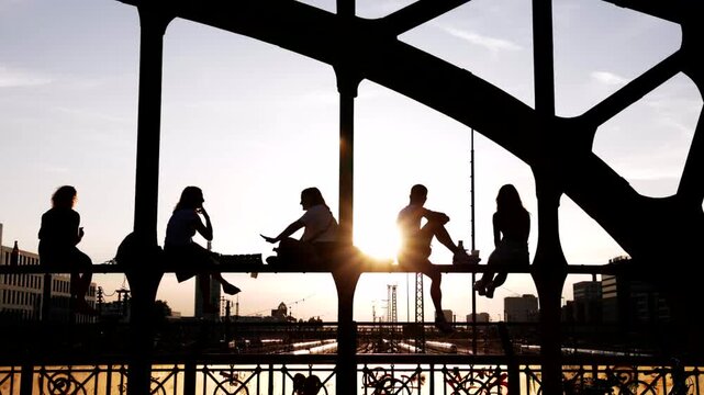 Junge Menschen Stadtbewohner genie&szlig;en den Sonnenuntergang Feierabend Freizeit Freundschaft Wochenende auf einer Br&uuml;cke vor urbaner st&auml;dtischer Kulisse Hackerbr&uuml;cke M&uuml;nchen