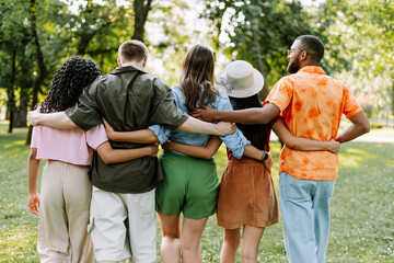 Group of diverse friends, women and men walking together in the park