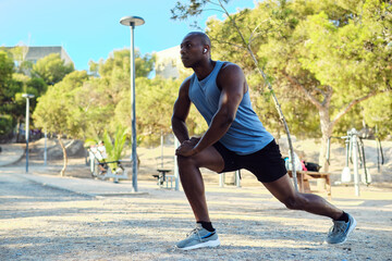 African athletic man dressed in sleeveless blue shirt, black shorts do leg stretch or warming up...
