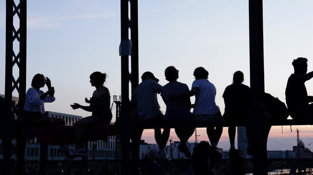 Junge Menschen Stadtbewohner genie&szlig;en den Sonnenuntergang Feierabend Freizeit Freundschaft Wochenende auf einer Br&uuml;cke vor urbaner st&auml;dtischer Kulisse Hackerbr&uuml;cke M&uuml;nchen