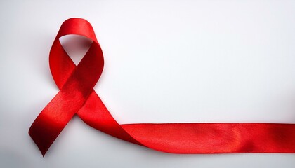 Closeup red ribbon HIV, world AIDS day awareness ribbon on white background. Healthcare and medicine concept.