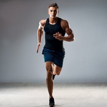 Full length portrait of active young muscular running man,