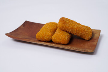 American Risoles or risoles mayo is a traditional Indonesian snack filled with smoked beef or sausage, boiled eggs & mayonnaise. Crispy texture on the outside. Risoles on wood plate isolated white.