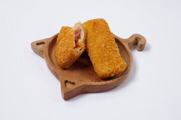 American Risoles or risoles mayo is a traditional Indonesian snack filled with smoked beef or sausage, boiled eggs & mayonnaise. Crispy texture on the outside. Risoles on wood plate isolated white.