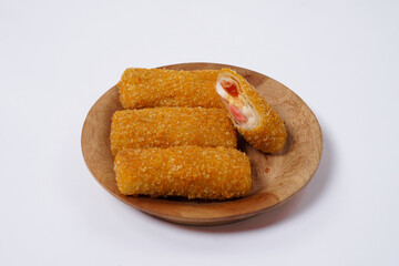 American Risoles or risoles mayo is a traditional Indonesian snack filled with smoked beef or sausage, boiled eggs & mayonnaise. Crispy texture on the outside. Risoles on wood plate isolated white.