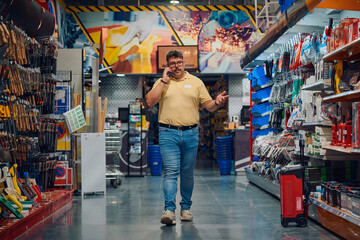 Employee engaged in phone conversation while working in a retail store aisle during daytime hours