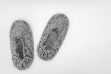 Fluffy gray home slippers isolated on white background. Bed shoes accessory footwear. Top view or flat lay.