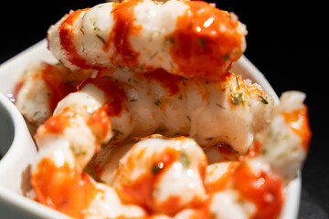 Bowl of food with sauce and white meat. Surimi in the form of shrimp.