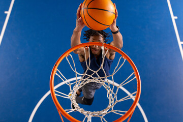 Playing basketball, woman jumping and dunking ball into hoop on court © WavebreakMediaMicro
