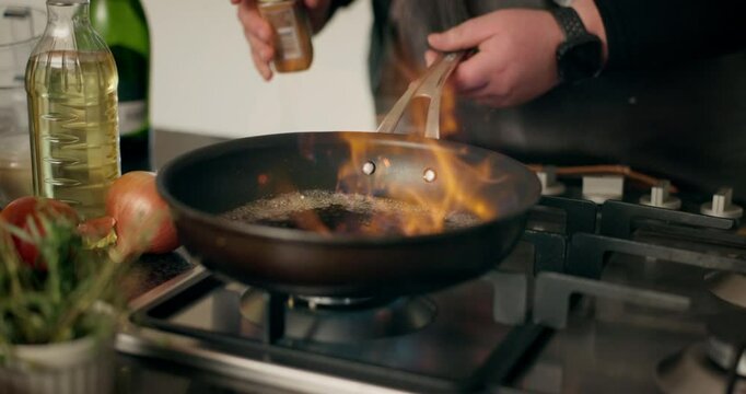 Food, flame and frying pan with hands of person in kitchen for cooking, fire and meal prep. Nutrition, cuisine and dinner with chef and flambe at home for wellness, dining and healthy ingredients
