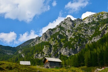 Wooden huts at Konjščica alpine pasture bellow the mountains in Julian alps, Slovenia