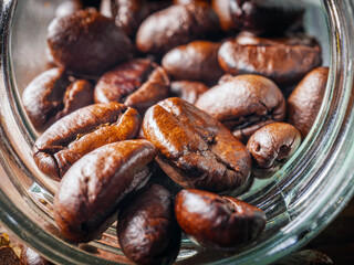 Close-up of roasted coffee beans poured out of a glass jar, Coffee beans spilled out from jar,Close up