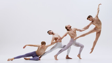 Obraz premium Dancers execute smooth transition from grounded to elevated poses, their movements capturing essence of both agility and grace. Concept of music and dance, modern and classical art.