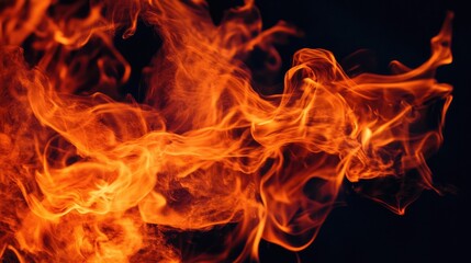 Fototapeta premium vibrant orange and red flames dancing against a black background, capturing the raw energy of fire