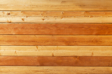 Fototapeta premium Natural wooden background from square timber on the log wall of new wooden house. Concept of wooden ecological building material. Wood texture. Background for design or text, copy space, mock up