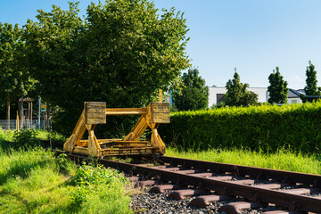 A yellow buffer stop at the end of a railway track.