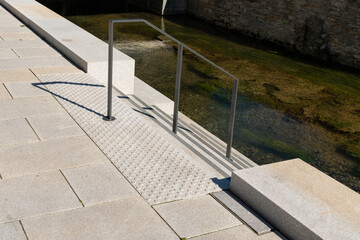 A stone and concrete pedestrian ramp leading to the water
