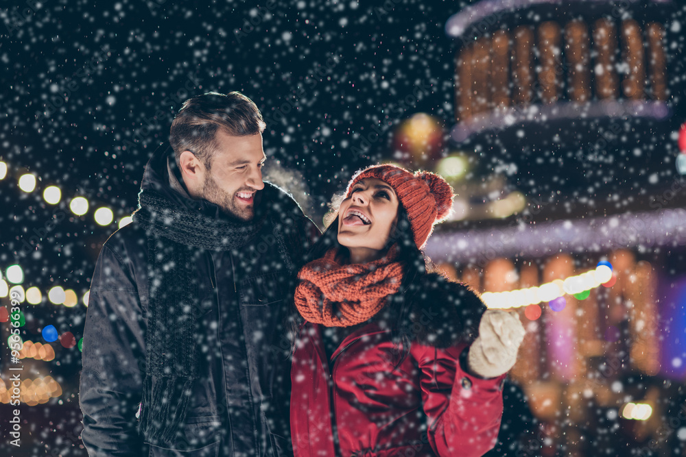 Poster Photo of two funny people spend x-mas evening together playful good mood catching snowflakes by tongue wearing warm coats outdoors